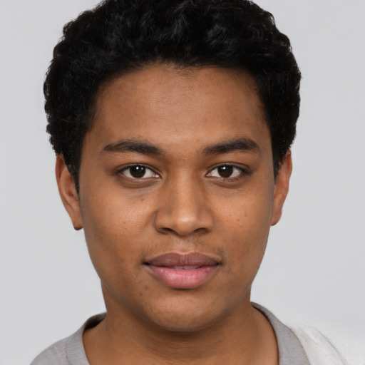 Joyful black young-adult male with short  black hair and brown eyes