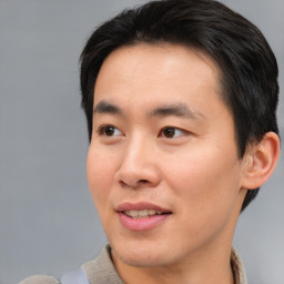 Joyful asian young-adult male with short  brown hair and brown eyes