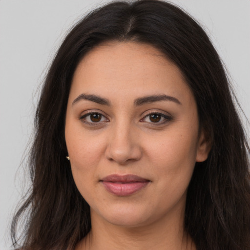 Joyful latino young-adult female with long  brown hair and brown eyes