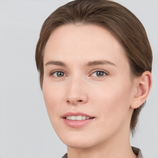 Joyful white young-adult female with short  brown hair and grey eyes