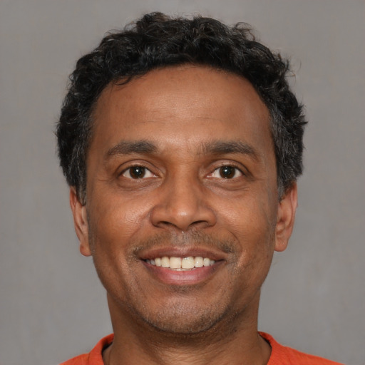 Joyful black adult male with short  brown hair and brown eyes