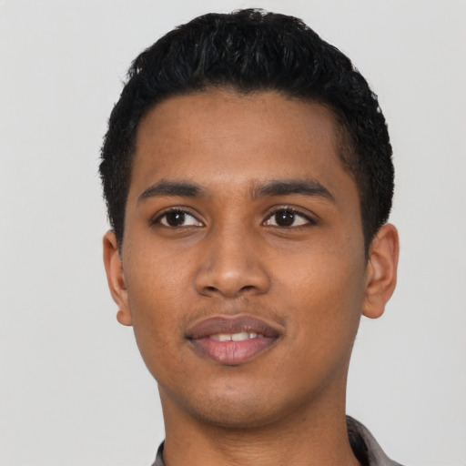 Joyful black young-adult male with short  black hair and brown eyes