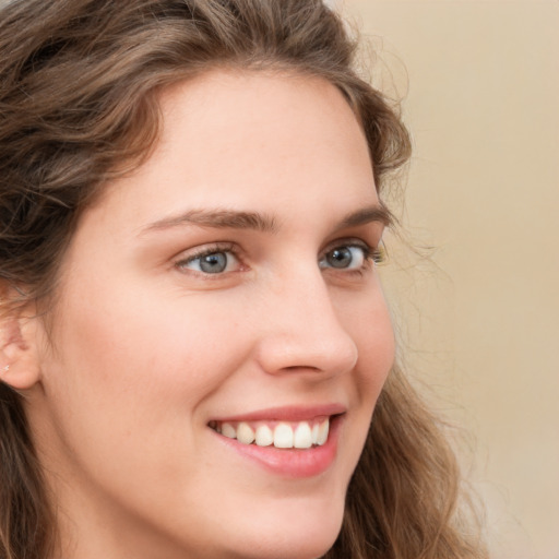 Joyful white young-adult female with long  brown hair and green eyes