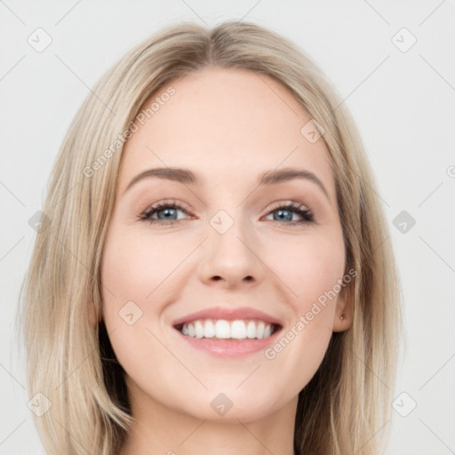 Joyful white young-adult female with long  brown hair and blue eyes