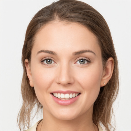 Joyful white young-adult female with medium  brown hair and grey eyes