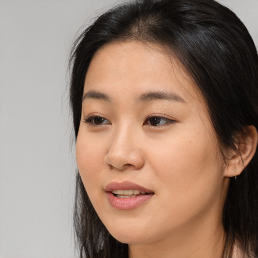Joyful asian young-adult female with long  brown hair and brown eyes