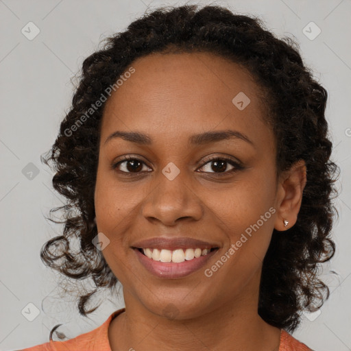 Joyful black young-adult female with long  brown hair and brown eyes