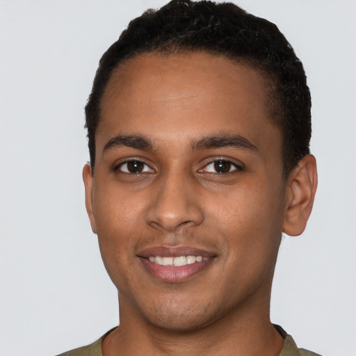 Joyful black young-adult male with short  brown hair and brown eyes