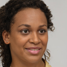 Joyful black young-adult female with long  brown hair and brown eyes