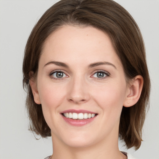 Joyful white young-adult female with medium  brown hair and green eyes