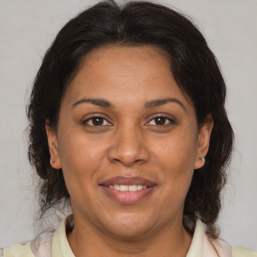 Joyful latino adult female with medium  brown hair and brown eyes