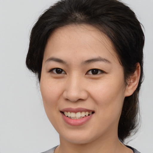 Joyful asian young-adult female with medium  brown hair and brown eyes