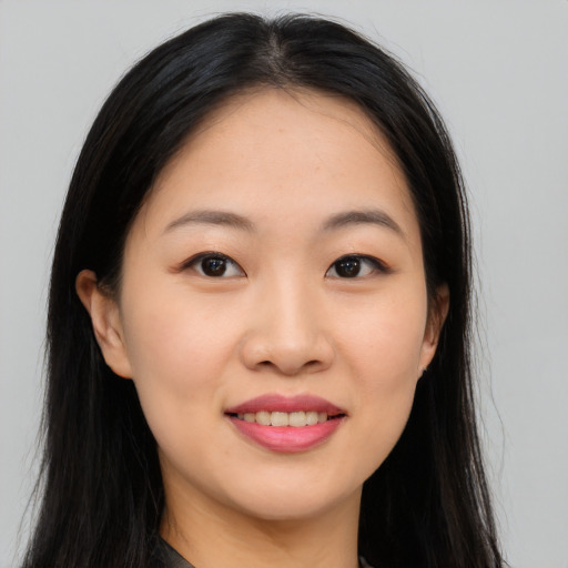 Joyful asian young-adult female with long  black hair and brown eyes