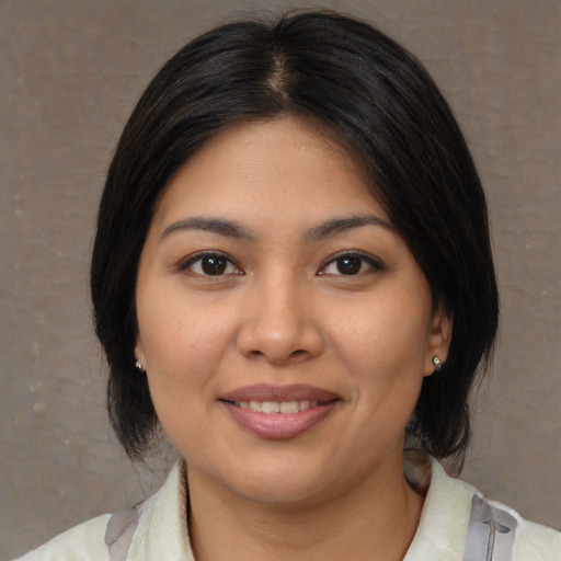 Joyful latino young-adult female with medium  brown hair and brown eyes