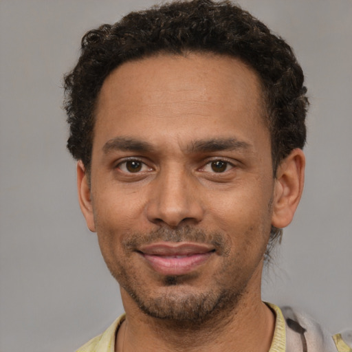 Joyful black young-adult male with short  black hair and brown eyes