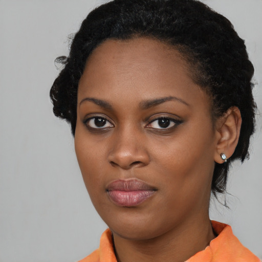 Joyful black young-adult female with short  black hair and brown eyes