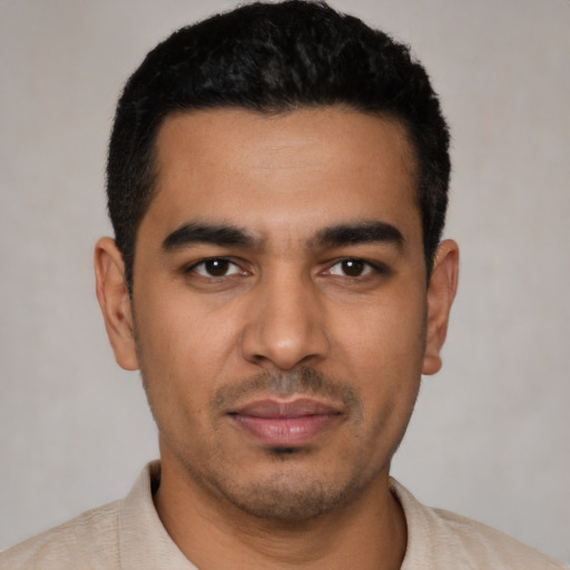 Joyful latino young-adult male with short  black hair and brown eyes