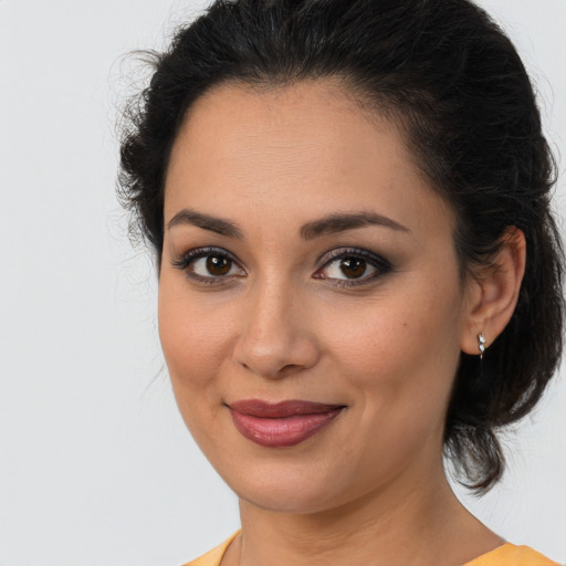 Joyful latino young-adult female with medium  brown hair and brown eyes