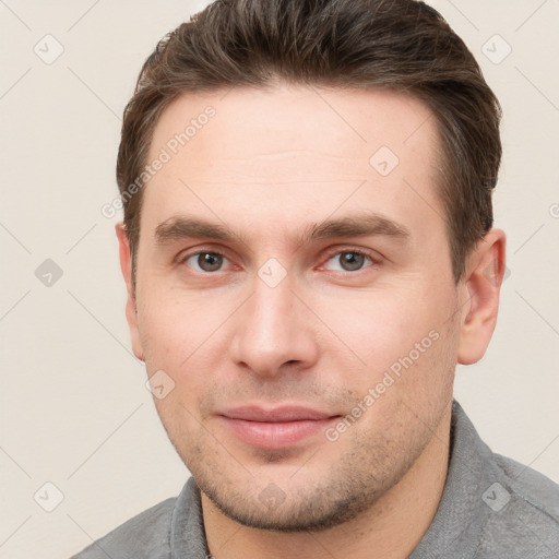 Joyful white young-adult male with short  brown hair and grey eyes