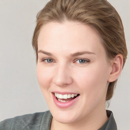 Joyful white young-adult female with short  brown hair and blue eyes