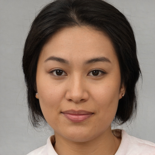 Joyful asian young-adult female with medium  brown hair and brown eyes