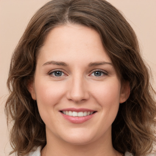 Joyful white young-adult female with long  brown hair and green eyes