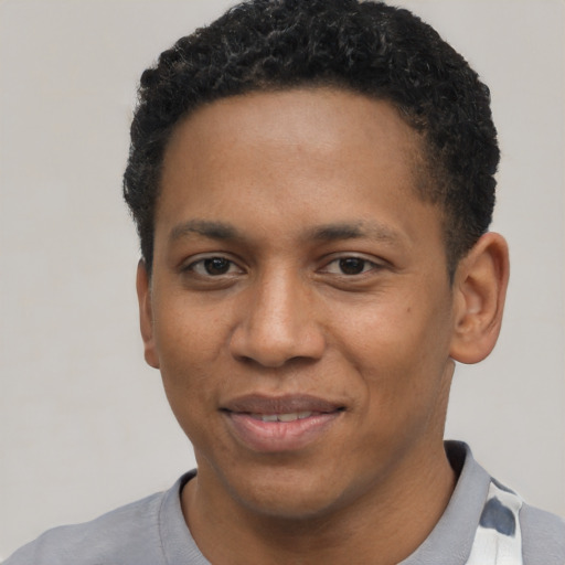 Joyful black young-adult male with short  black hair and brown eyes
