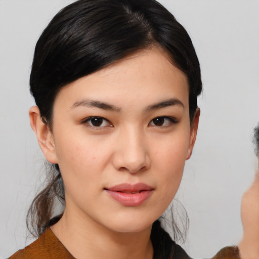 Joyful asian young-adult female with medium  brown hair and brown eyes