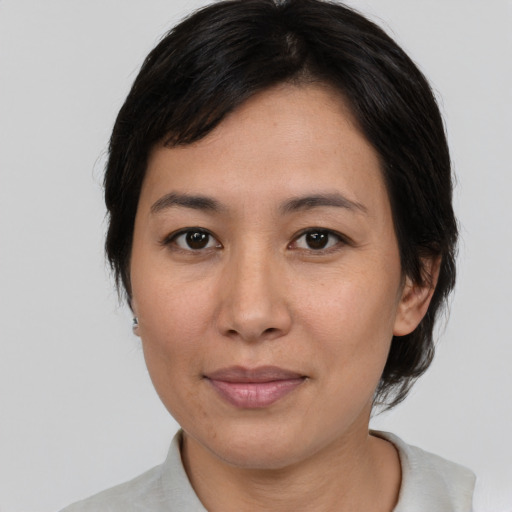 Joyful asian adult female with medium  black hair and brown eyes