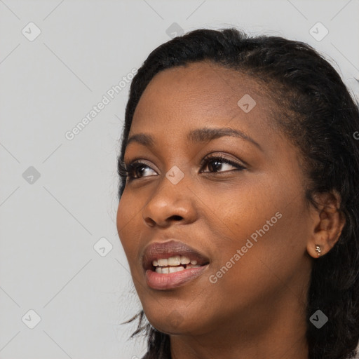 Joyful black young-adult female with long  black hair and brown eyes