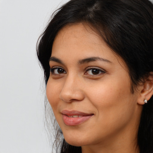 Joyful latino young-adult female with long  brown hair and brown eyes