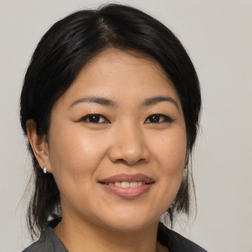 Joyful asian young-adult female with medium  brown hair and brown eyes