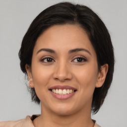 Joyful latino young-adult female with medium  brown hair and brown eyes