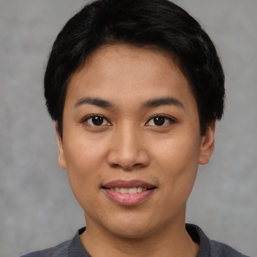 Joyful asian young-adult female with short  black hair and brown eyes