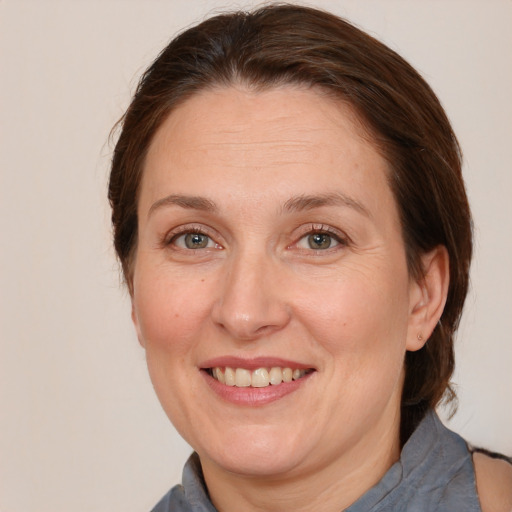 Joyful white adult female with medium  brown hair and grey eyes