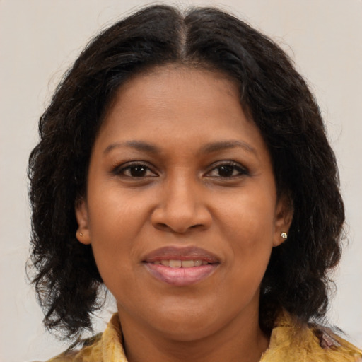 Joyful black adult female with medium  brown hair and brown eyes