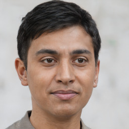 Joyful latino young-adult male with short  brown hair and brown eyes