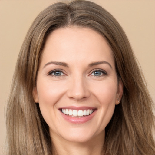 Joyful white young-adult female with long  brown hair and brown eyes