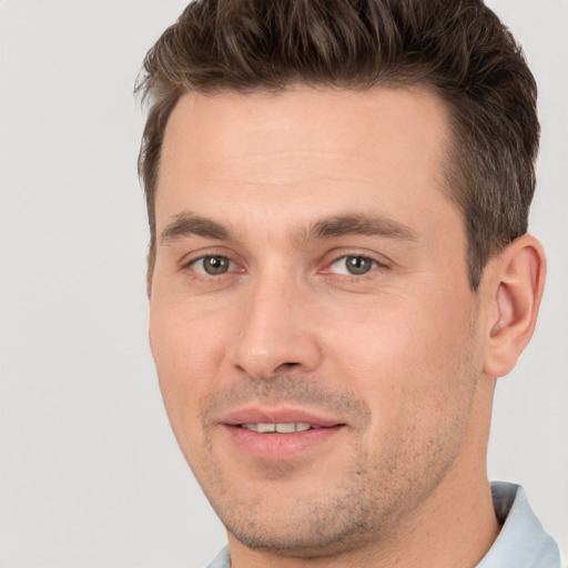 Joyful white young-adult male with short  brown hair and brown eyes