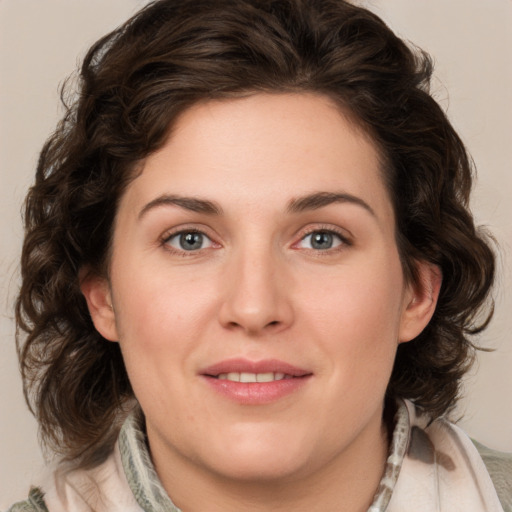 Joyful white young-adult female with medium  brown hair and green eyes