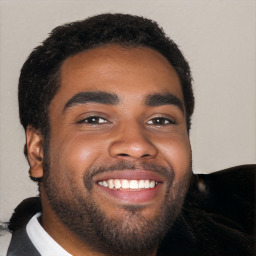 Joyful black young-adult male with short  black hair and brown eyes