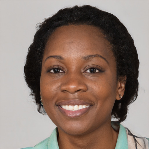 Joyful black young-adult female with long  black hair and brown eyes