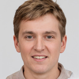 Joyful white young-adult male with short  brown hair and grey eyes