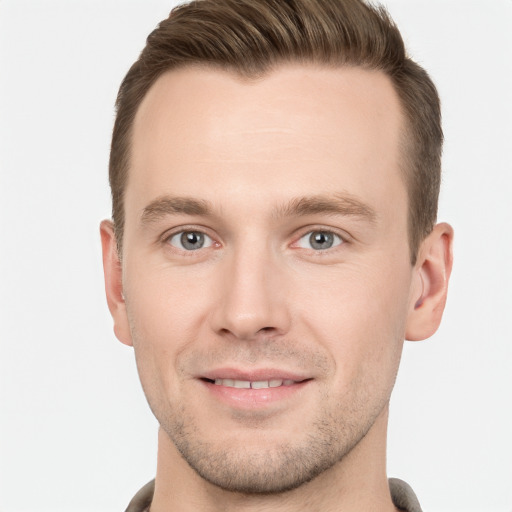 Joyful white young-adult male with short  brown hair and grey eyes