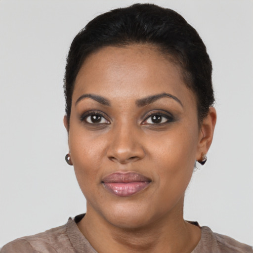 Joyful black young-adult female with short  black hair and brown eyes