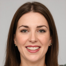 Joyful white young-adult female with long  brown hair and green eyes