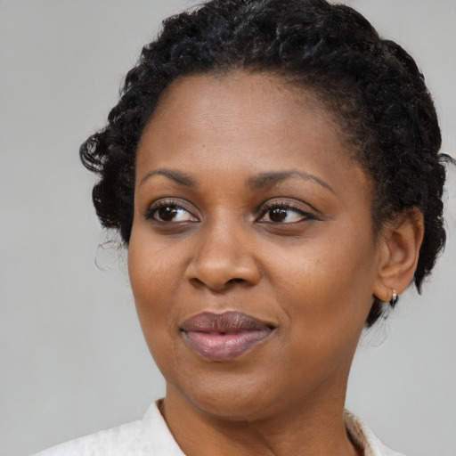 Joyful black adult female with short  black hair and brown eyes
