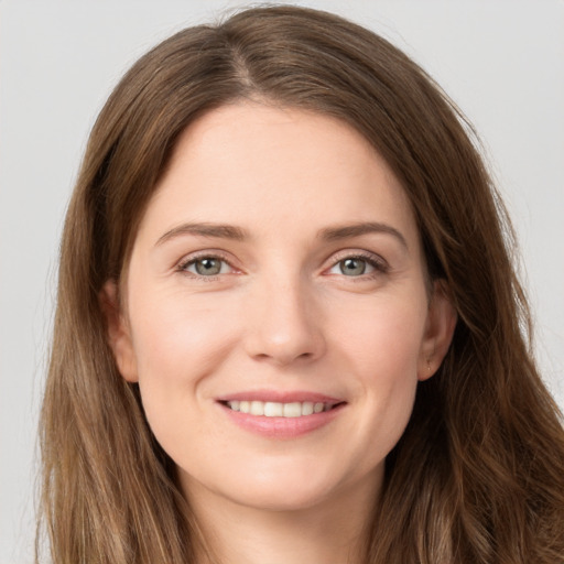 Joyful white young-adult female with long  brown hair and green eyes