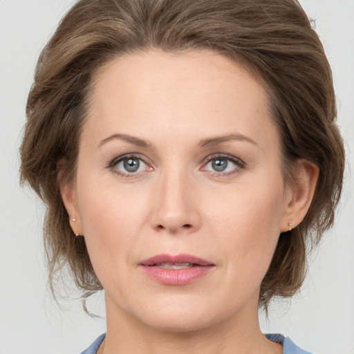 Joyful white adult female with medium  brown hair and grey eyes