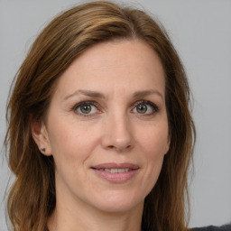 Joyful white adult female with long  brown hair and grey eyes